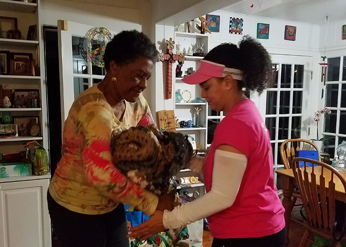 Alma Jordan and Maribel Figueroa pack one of the many mats woven from plastic grocery bags by Dr. Campbell's church. The mats provide insulation for those whose only bed is the ground. 