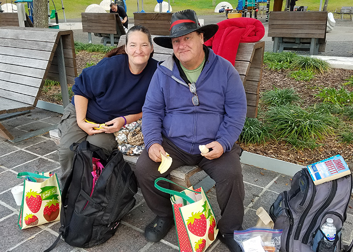 Maggie and Cowboy, a homeless couple, enjoy the contents of their care bag at Curtis Hixon Waterfront Park. 