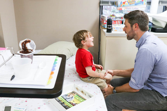 Harry "Will" Coleman IV plays with his father while they await the doctor in the exam room. Will says he likes peanuts and wishes he could eat them because his friends can.