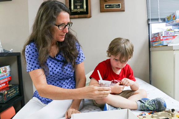 Michelle Twitmyer, a clinical research coordinator, gives Will Coleman a snack with peanut protein to build his tolerance.