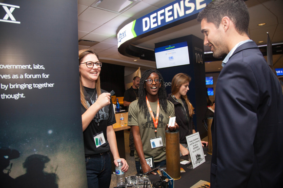 (L-R) Rachel Murphy, Tania Steele, and Taylor Szostak talk to Dijmo Serodio about their experience with Sofwerx.