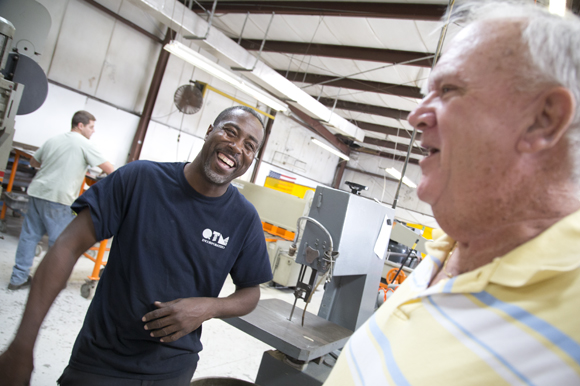 Welder Carlos Betts and CEO Dick Peck share a laugh.